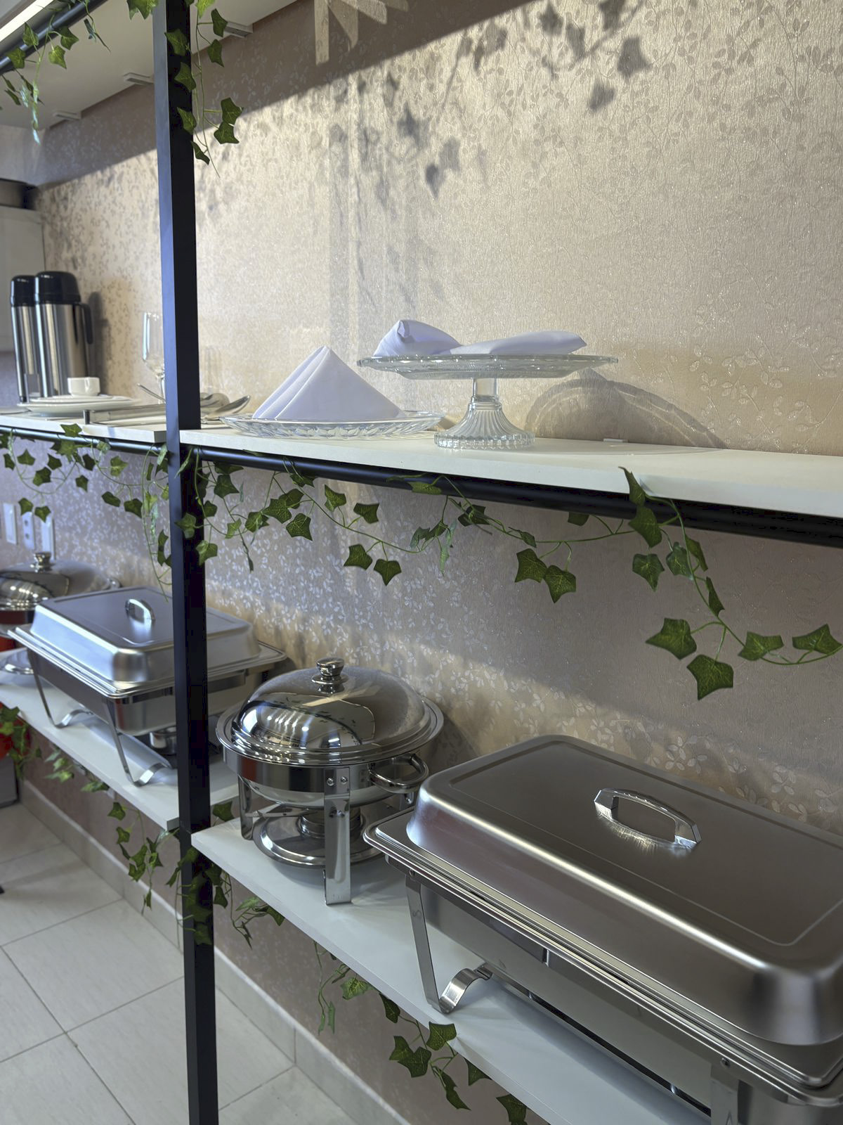 Estrutura de buffet com rechauds de inox e prateleira decorada