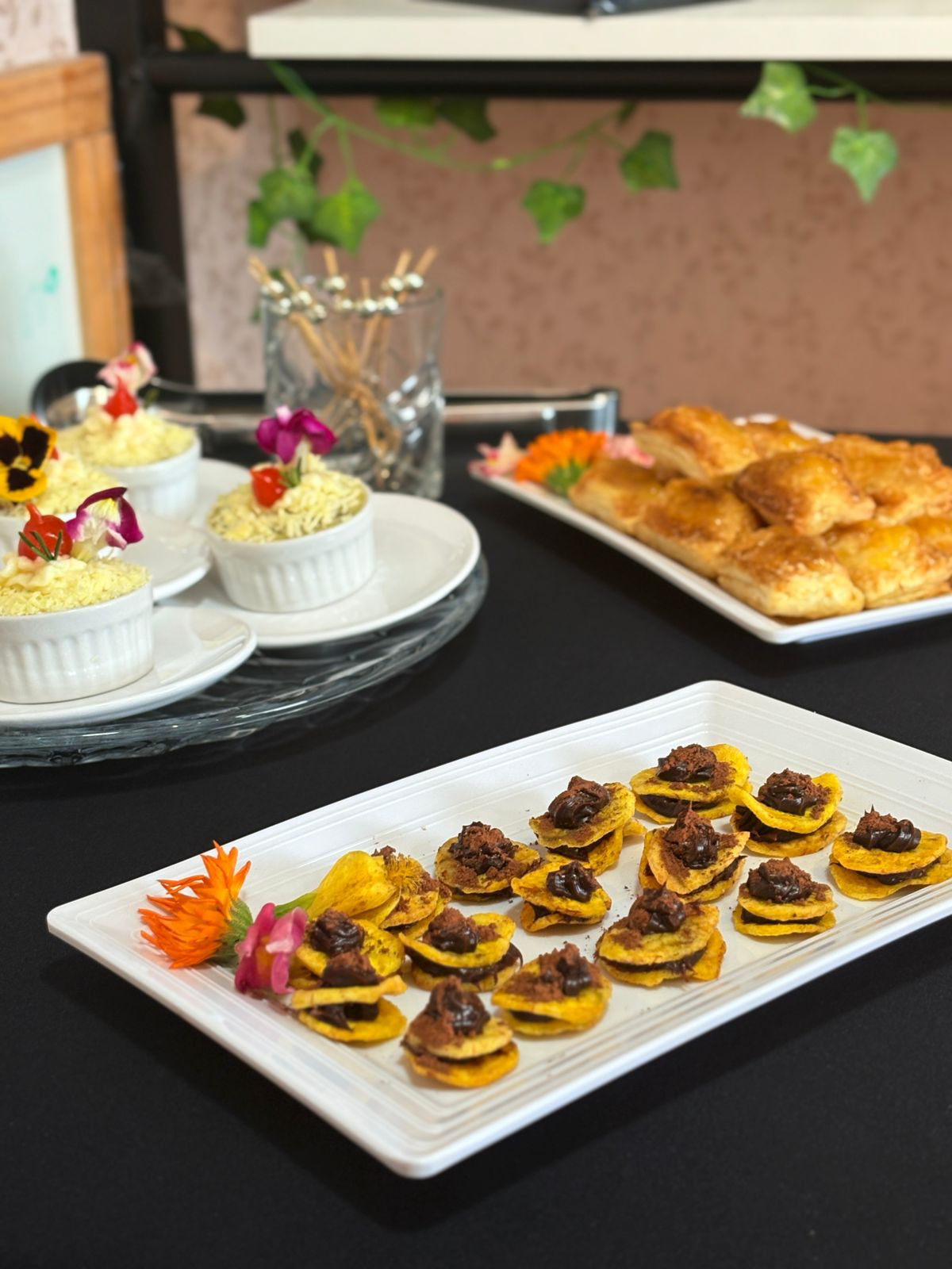 Mesa com canapés decorados, ramequins e folhados